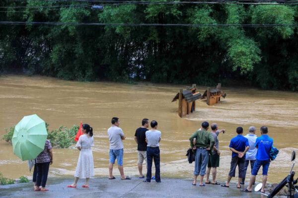 People are watching a floodwater submerged street in Rong'an County in China's southern Guangxi region on June 10, 2020. (STR/AFP via Getty Images)