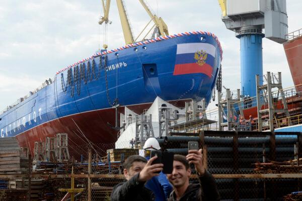 Men take selfies during the float out of the Sibir (Siberia) nuclear-powered icebreaker at the Baltic shipyard in Saint Petersburg, Russia, on Sept. 22, 2017. (Olga Maltseva/AFP via Getty Images)
