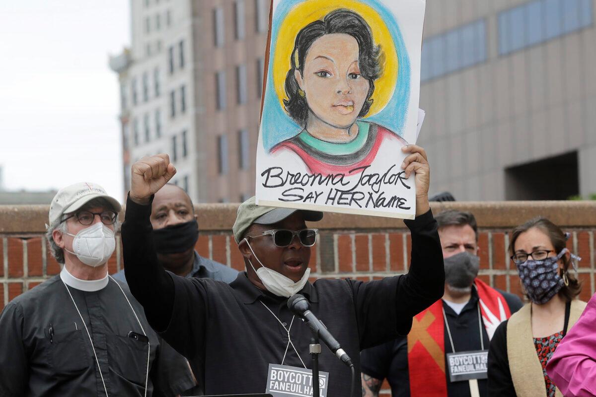 A man holds up a placard showing fallen Breonna Taylor, as he addresses a rally in Boston, Mass., on June 9, 2020. (AP Photo/Steven Senne)