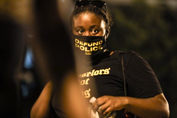 A woman with a “Defund Police” face mask during a protest near the White House following the May 25 death of George Floyd in police custody, in Washington on June 6, 2020. (Charlotte Cuthbertson/The Epoch Times)