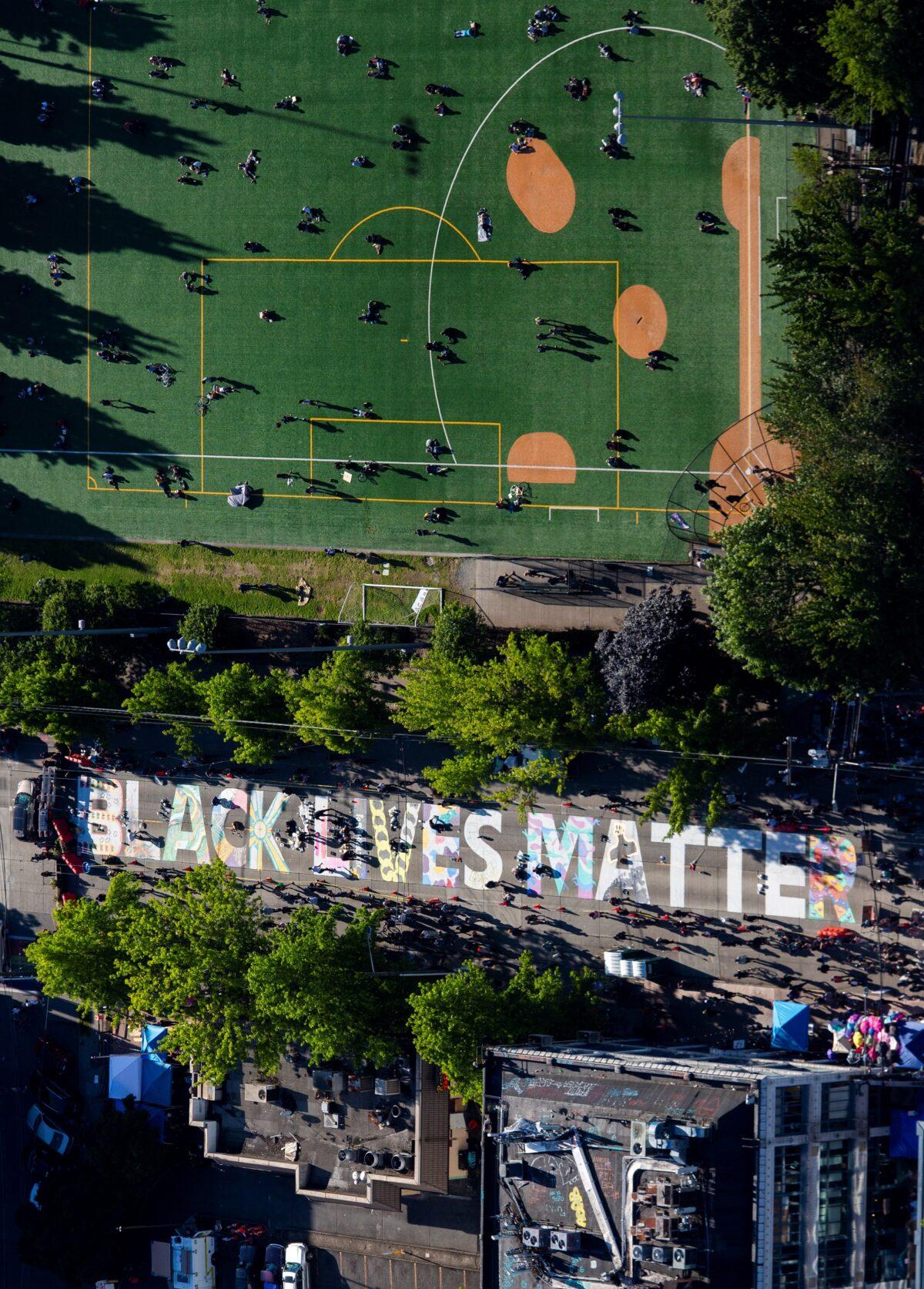 Artists fill in the letters of a "Black Lives Matter" mural on E. Pine Street as protesters establish what they call an autonomous zone near the Seattle Police Department's East Precinct in this aerial photo taken over Seattle, Wash., on June 11, 2020. (Lindsey Wasson/Reuters)