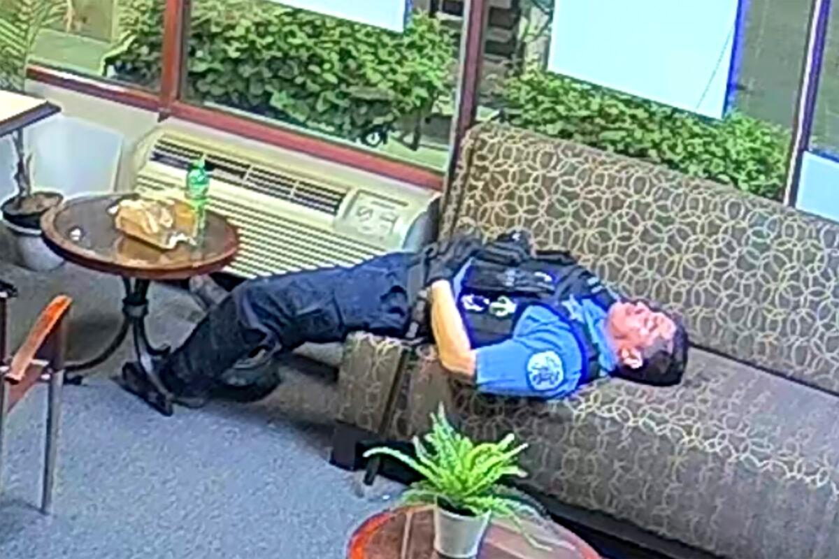 A Chicago police officer lies on a couch inside Rep. Bobby Rush's (D-Ill.) burglarized congressional campaign office in Chicago, Ill., on May 31, 2020. (Congressman Bobby Rush's Campaign Office via AP)