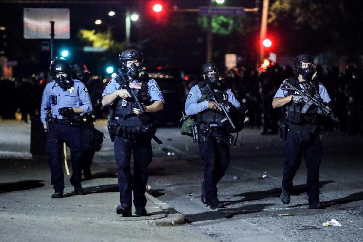  Police take back the streets at around midnight after firing copious amounts of tear gas to disperse protesters and rioters outside the Minneapolis Police 5th Precinct during the fourth night of protests and violence following the death of George Floyd, in Minneapolis, Minn., on May 29, 2020. (Charlotte Cuthbertson/The Epoch Times)