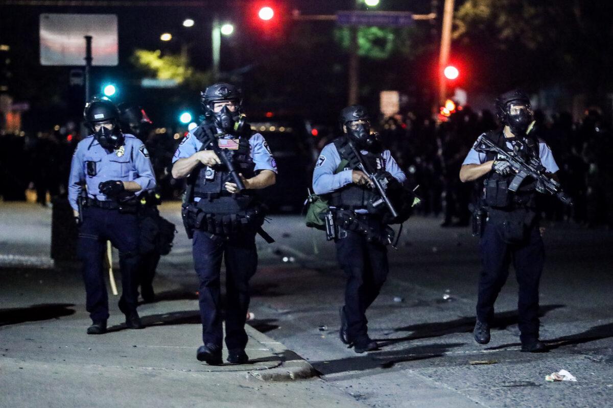 Police take back the streets at around midnight after firing copious amounts of tear gas to disperse protesters and rioters outside the Minneapolis Police 5th Precinct during the fourth night of protests and violence following the death of George Floyd, in Minneapolis, Minn., on May 29, 2020. (Charlotte Cuthbertson/The Epoch Times)