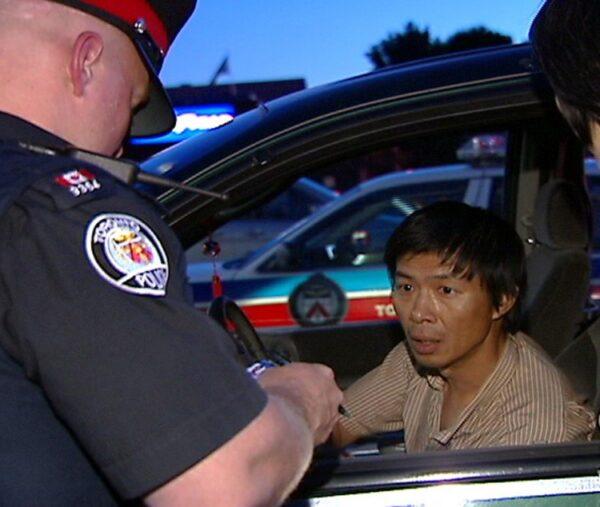 Toronto police question Lu Ping over his delivery of Crescent Chau's latest anti-Falun Gong tabloid on June 30, 2007, at the Asian Farm grocery store in northeast Toronto. (NTDTV)