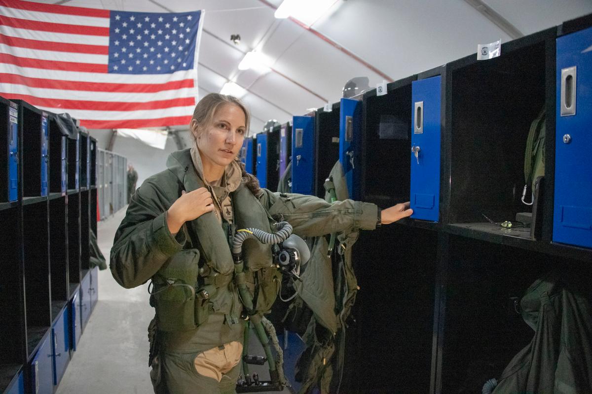 U.S. Air Force Capt. Emily Thompson, 421st Expeditionary Fighter Squadron pilot, dons flight equipment recently at the Aircrew Flight Equipment shop at Al Dhafra Air Base, United Arab Emirates. (<a href="https://www.dvidshub.net/image/6235474/first-female-fighter-pilot-conduct-f-35-combat-mission">Tech. Sgt. Kat Justen</a>/U.S. Air Force)