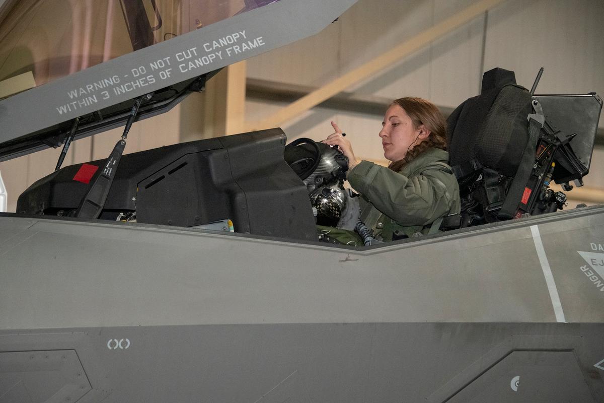 U.S. Air Force Capt. Emily Thompson, 421st Expeditionary Fighter Squadron pilot, dons her helmet recently prior to a mission at Al Dhafra Air Base, United Arab Emirates. (<a href="https://www.dvidshub.net/image/6235475/first-female-fighter-pilot-conduct-f-35-combat-mission">Tech. Sgt. Kat Justen</a>/U.S. Air Force)