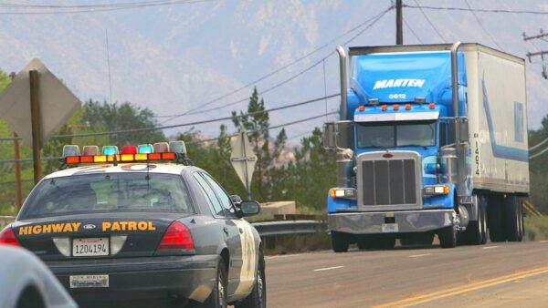 A trucker approaches a highway patrolman in a file photo taken on July 23, 2007, near Wrightwood, California, 50 miles northeast of Los Angeles. (Photo by David McNew/Getty Images)