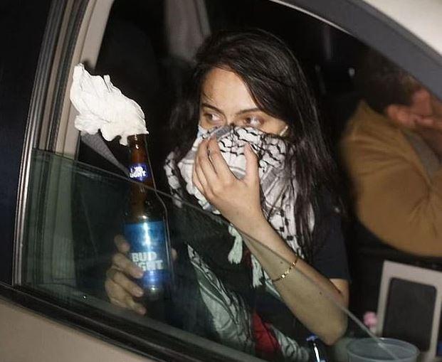 A woman identified as Urooj Rahman holds a Molotov cocktail in a still image from surveillance footage. (U.S. Attorney's Office-Eastern District of New York)