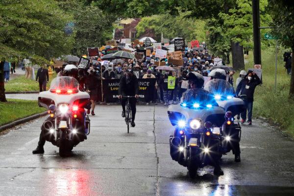 Police on motorcycles ride ahead of protesters organized by Black Lives Matter in Seattle, Wash., on June 12, 2020. (AP Photo/Ted S. Warren)