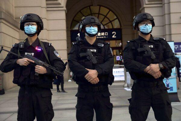 Police officers stand guard outside Hankou Railway Station in Wuhan city, Hubei Province, China, on April 8, 2020. (Ng Han Guan/AP Photo)