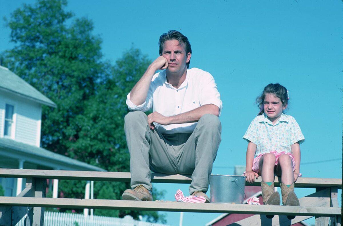 Ray (Kevin Costner) and Karin (Gaby Hoffmann) sit on the bleachers waiting, in "Field of Dreams." (Universal Pictures)