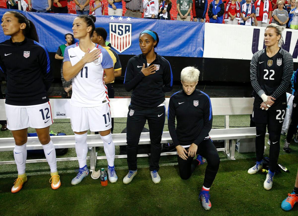 U.S. player Megan Rapinoe (R) kneels next to teammates Christen Press (12), Ali Krieger (11), Crystal Dunn (16), and Ashlyn Harris (22) as the national anthem is played before the team's exhibition soccer match against the Netherlands in Atlanta on Sept. 18, 2016. (John Bazemore/AP Photo)