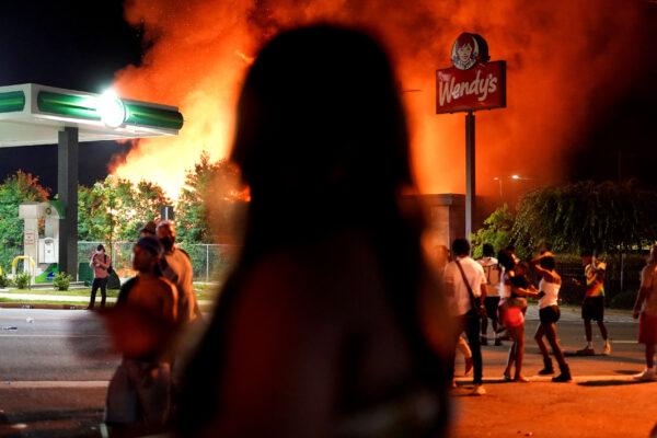 People watch as a Wendy’s burns following a rally against racial inequality and the police shooting death of Rayshard Brooks, in Atlanta, Ga., on June 13, 2020. (Elijah Nouvelage/Reuters)