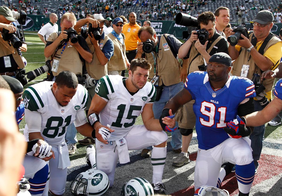Tebow and Dustin Keller of the New York Jets pray with teammates and members of the Buffalo Bills at MetLife Stadium in East Rutherford, New Jersey, on Sept. 9, 2012. (Jeff Zelevansky/Getty Images)