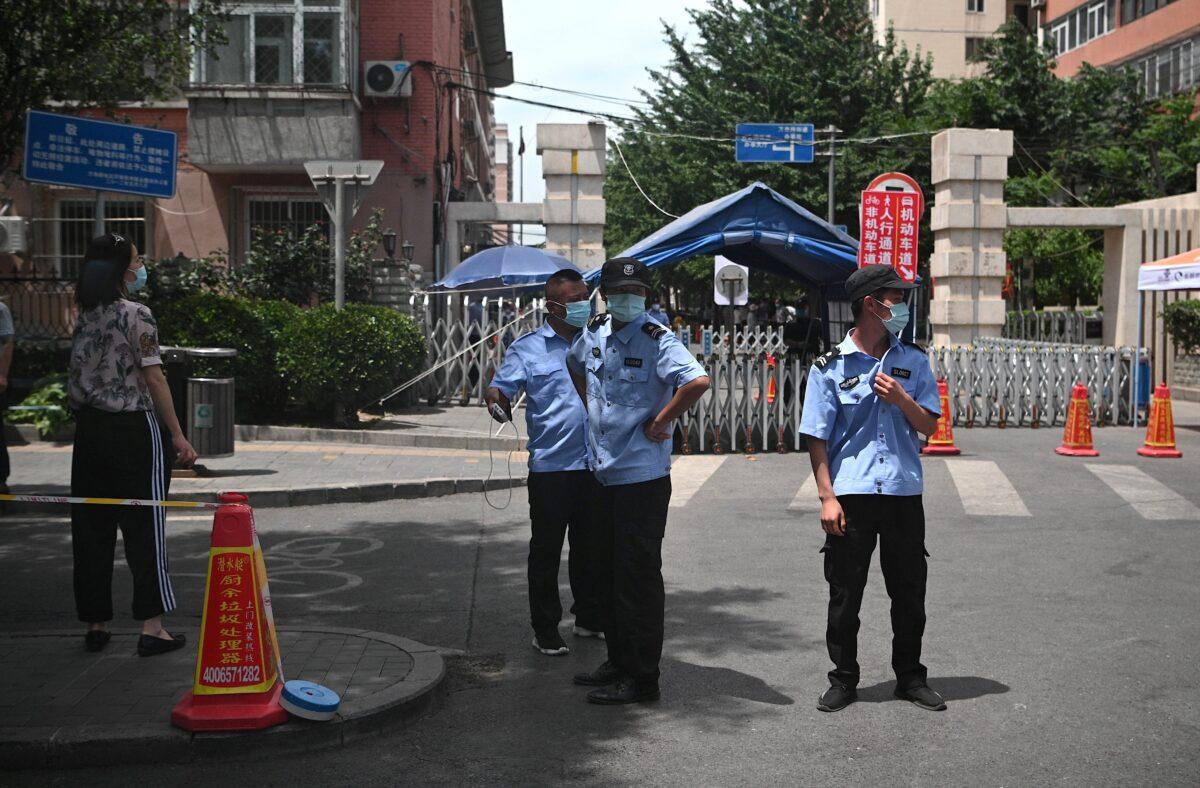 Security personnel stand in front of a residential area under lockdown near Yuquan East Market in Beijing, China, on June 15, 2020. (Noel Celis/AFP via Getty Images)