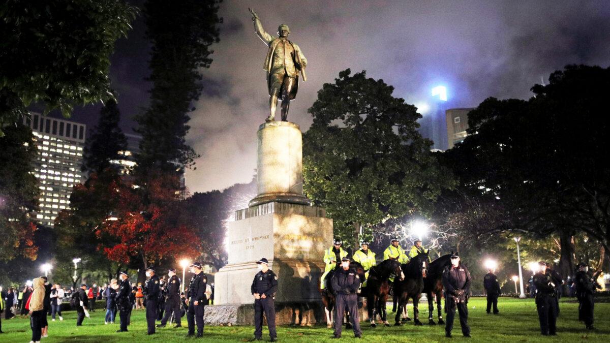 Police officers stand guard around the statue of Captain James Cook, in Sydney, Australia, June 12. (Loren Elliott/Reuters)