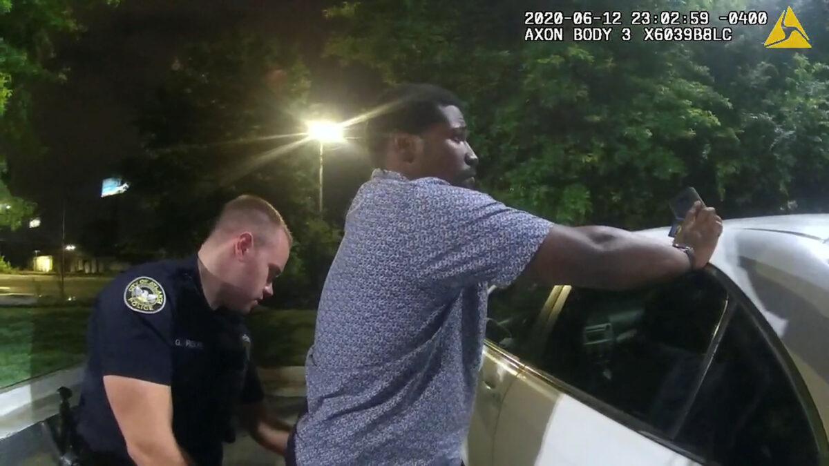 Then-Atlanta Police Department officer Garrett Rolfe searches 27-year-old Rayshard Brooks in a Wendy's restaurant parking lot in a still image from the video body camera of officer Devin Bronsan in Atlanta, Ga., on June 12, 2020. (Atlanta Police Department via Reuters)