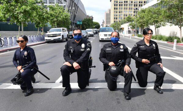 Los Angeles Police Department officers kneel during a rally led by Baptist Ministers to City Hall in memory of George Floyd, on June 2, 2020. (Frederic J. Brown/AFP via Getty Images)