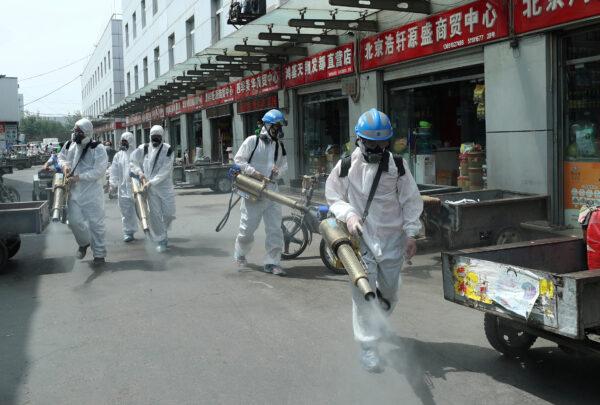 Volunteers in protective suits disinfect the Yuegezhuang wholesale market, following new cases of coronavirus disease (COVID-19) infections in Beijing, China on June 16, 2020. (China Daily via Reuters)