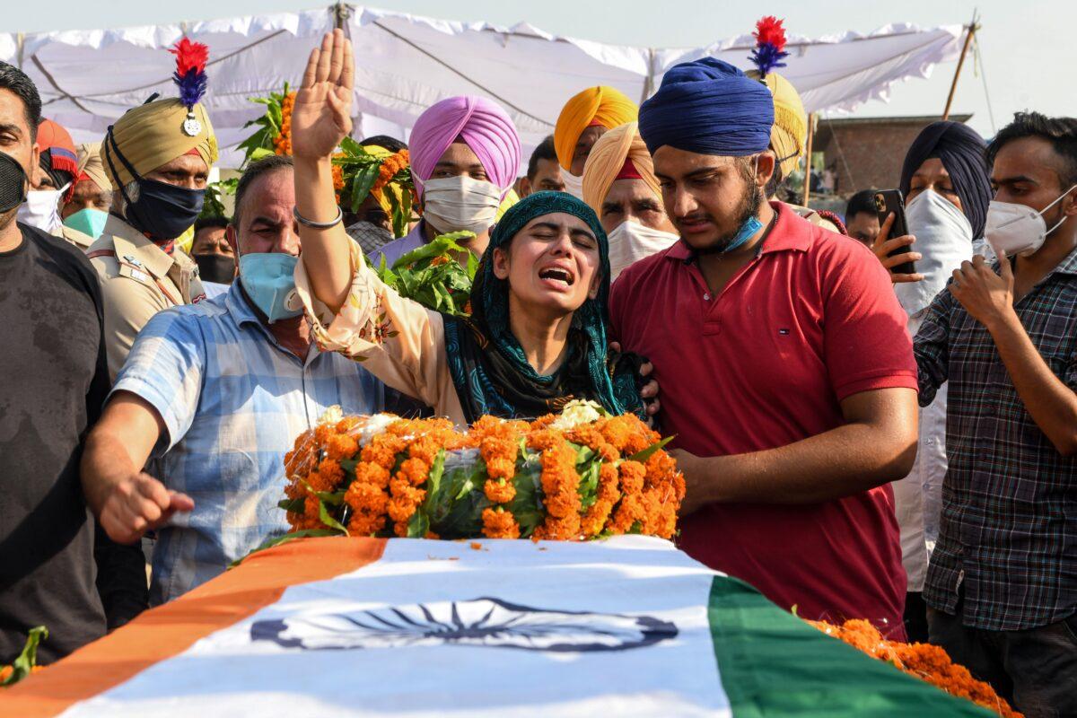 Sandeep Kaur (C) and her brother Prabhjot Singh (2R) react after laying the wreaths of flowers on the coffin of their father and soldier Satnam Singh who was killed in a recent clash with Chinese forces in the Galwan valley area, during the cremation ceremony at Bhojraj village near Gurdaspur on June 18, 2020. (Narinder Nanu / AFP via Getty Images)