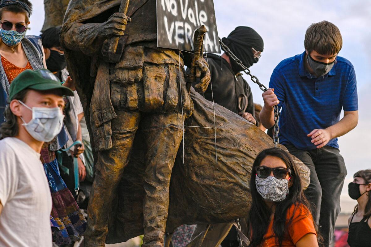 Protesters attach a chain to a statue of Spanish conqueror Juan de Oñate in Albuquerque, N.M., on June 15, 2020. (Anthony Jackson/The Albuquerque Journal via AP)