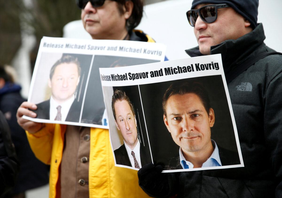 People hold signs calling for China to release Canadian detainees Michael Spavor and Michael Kovrig during an extradition hearing for Huawei Technologies Chief Financial Officer Meng Wanzhou at the B.C. Supreme Court in Vancouver, Canada, on March 6, 2019. (Lindsey Wasson/)