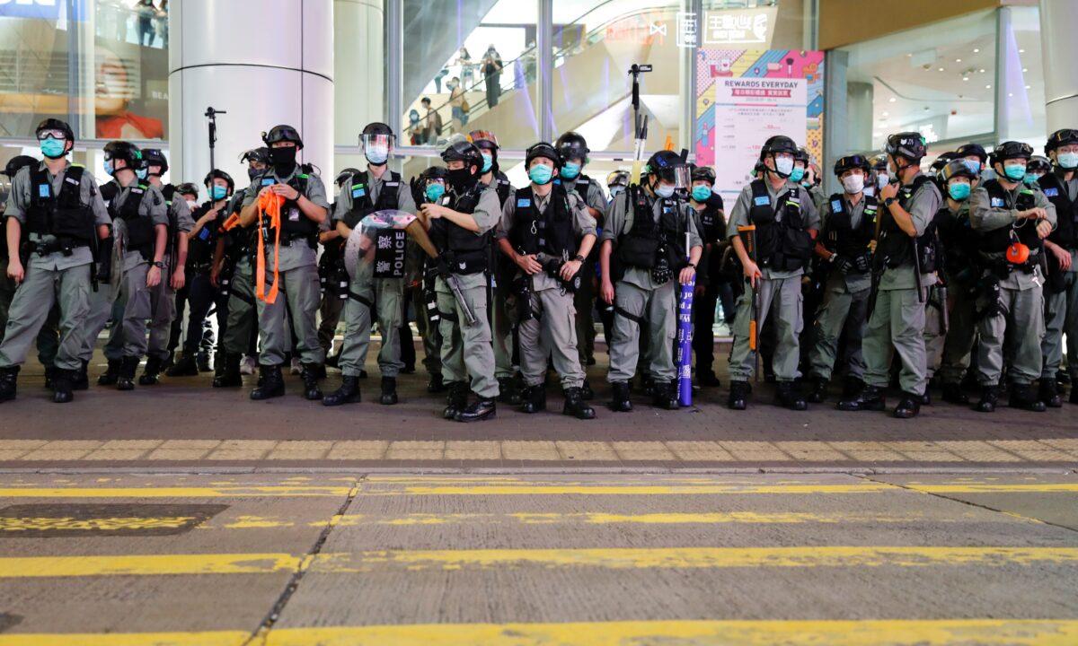 Riot police disperse stand guard as pro-democracy demonstrators take part a singing song protest at Mong Kok, Hong Kong, on June 12, 2020. (Tyrone Siu/Reuters)