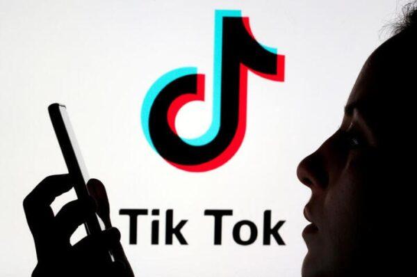 A person holds a smartphone as TikTok logo is displayed behind in this picture illustration taken on Nov. 7, 2019. (Dado Ruvic/Reuters)