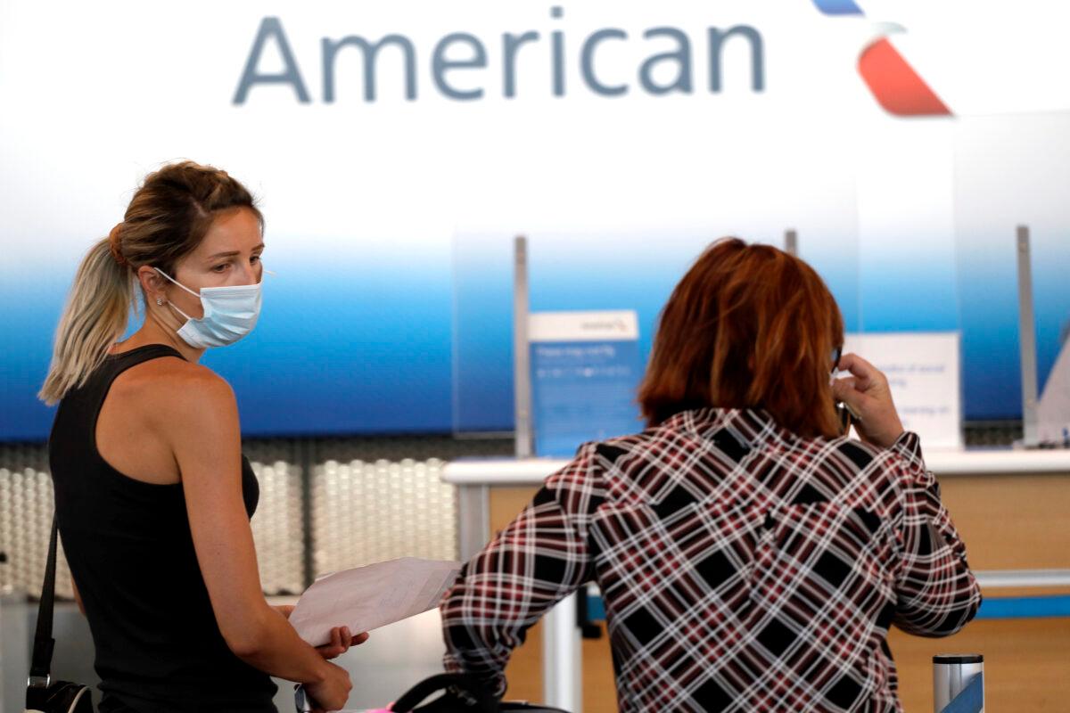 Travelers wear masks as they wait at the American Airlines ticket counter at O'Hare International Airport in Chicago, Ill., on June 16, 2020. (Nam Y. Huh/AP Photo)