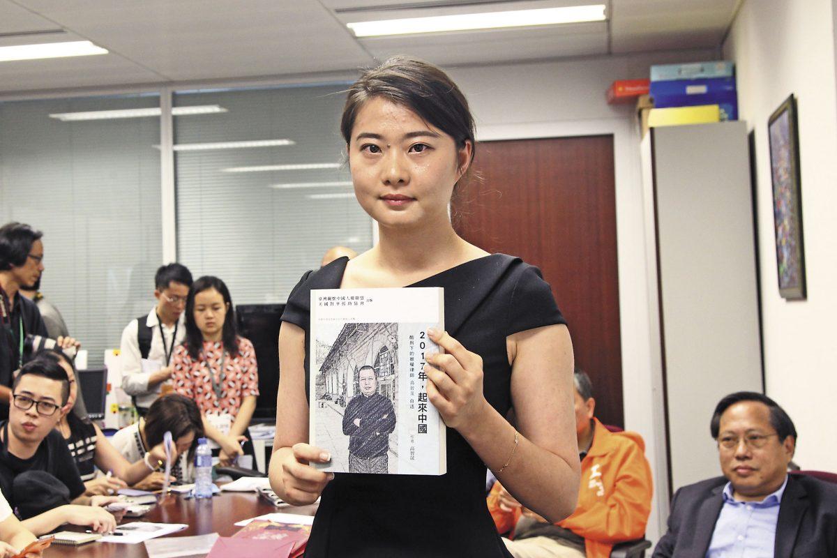 Grace Geng, Gao Zhisheng's daughter, holds a copy of Gao's book, “Year 2017: Stand Up China," at the book-launch ceremony in Hong Kong on June 16, 2016. (Stone Poon/The Epoch Times)