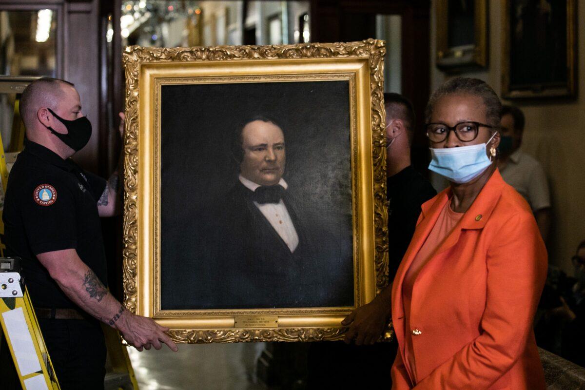 House Clerk Cheryl Johnson, right, looks on as Architect of the Capitol maintenance workers remove a painting of former confederate speaker James Orr of South Carolina, from the east staircase of the Speaker's lobby, on Capitol Hill in Washington on June 18, 2020. (Graeme Jennings/Pool/AFP/Getty Images)