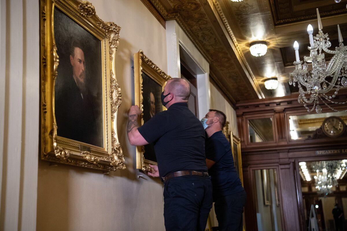 Architect of the Capitol workers remove the portrait of Confederate speaker James Orr from a wall in the Speaker's Lobby of the U.S. Capitol on Capitol Hill in Washington on June 18, 2020. (Graeme Jennings/Pool/AFP/Getty Images)