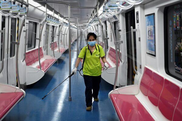 A staff member sprays disinfectant on a train at a subway station in Beijing, China on June 20, 2020. (STR/AFP via Getty Images)