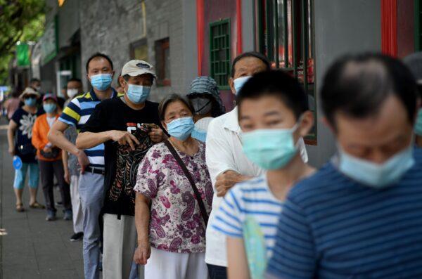 People line up to take a swab test during mass testing for the COVID-19 coronavirus in Beijing, China on June 21, 2020. (NOEL CELIS/AFP via Getty Images)