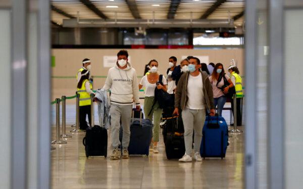 Passengers, wearing protective face masks, walk upon arrival from Paris at Adolfo Suarez Barajas airport as Spain reopens its borders to most European visitors after the CCP virus lockdown, in Madrid, Spain, June 21, 2020. (Sergio Perez/Reuters)