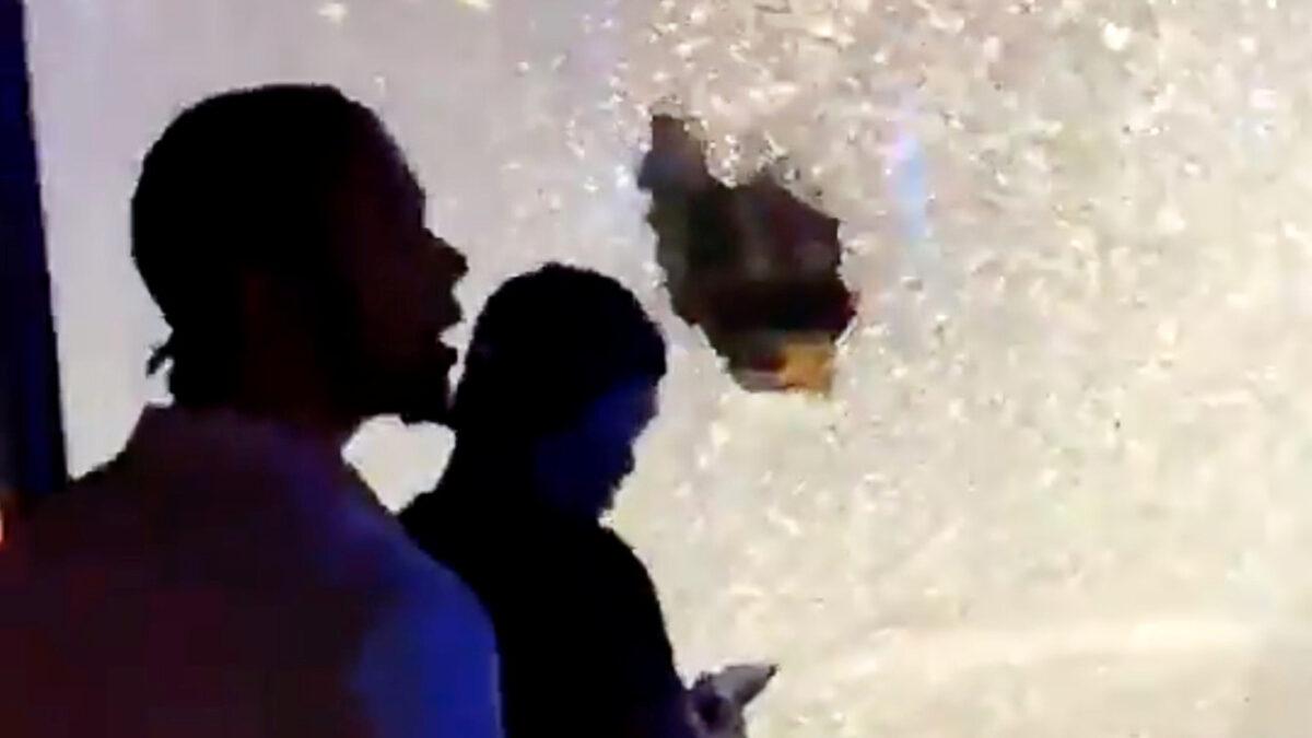 People pass by shattered glass on a shopfront after a shooting in Minneapolis, Minn., in this picture obtained from social media video, on June 21, 2020. (@MrMinnesota24/Twitter via Reuters)