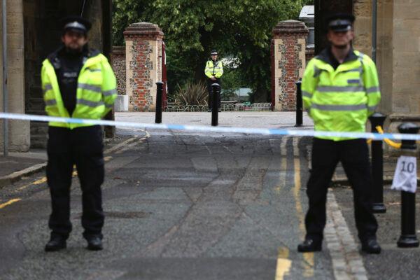 Police stand guard at the Abbey gateway of Forbury Gardens park in England's Reading town centre following a June 20 stabbing attack in the gardens, on June 21, 2020. (Jonathan Brady/PA via AP)