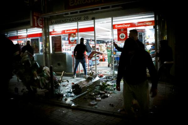 People break into a shop on Marienstrasse in Stuttgart, Germany, on June 21, 2020. (Julian Rettig/dpa via AP)