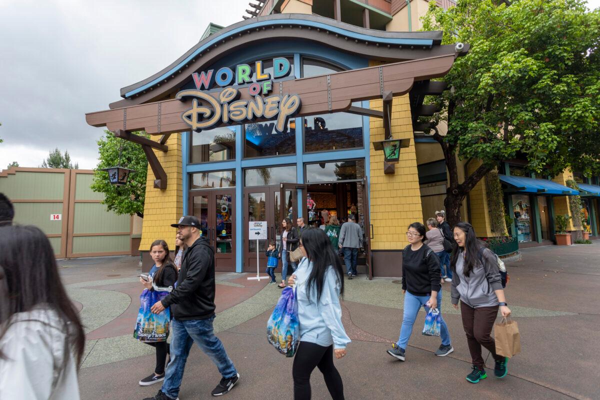 People walk near the World of Disney store in the Downtown Disney District shopping mall in Anaheim, Calif., on March 14, 2020. (David McNew/AFP via Getty Images)