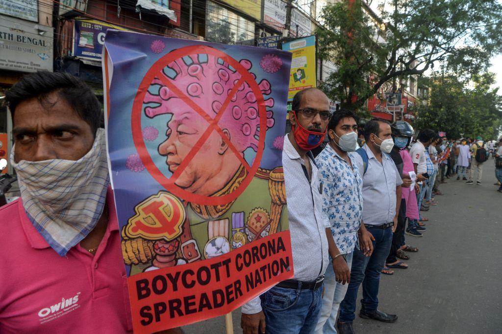 Activists of the ruling party, BJP stand in line as they hold posters during an anti-China protest in Siliguri on June 17, 2020. India and China held top-level talks on June 17 to "cool down the situation," Beijing said, after a violent border brawl that left at least 20 Indian soldiers dead. (Dipendu Dutta/AFP/Getty Images)