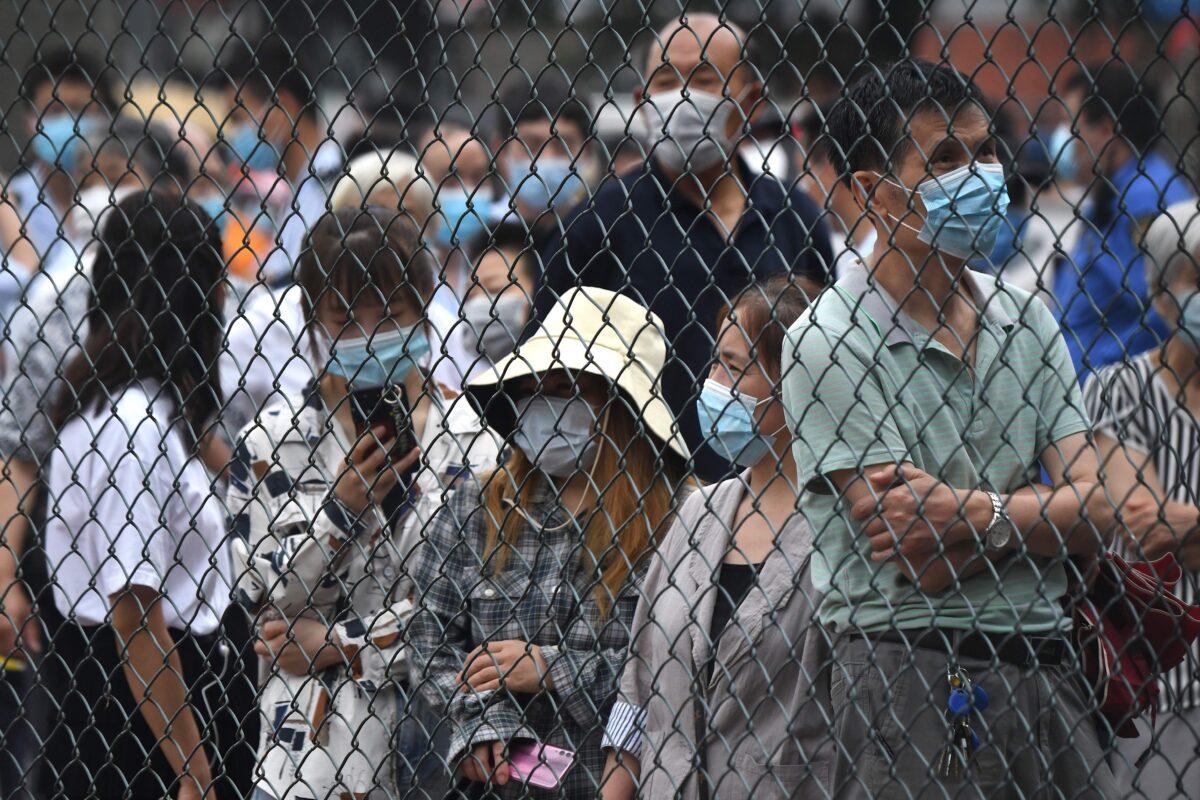 People gather at an outdoor area to take a swab test during mass testing for the COVID-19 in Beijing on June 23, 2020. (NOEL CELIS/AFP via Getty Images)