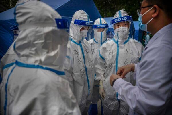 A Chinese doctor gives instruction to nurses in protective suits before performing nucleic acid swab tests for COVID-19 on citizens at a government testing site in Beijing, China on June 22, 2020. (Kevin Frayer/Getty Images)