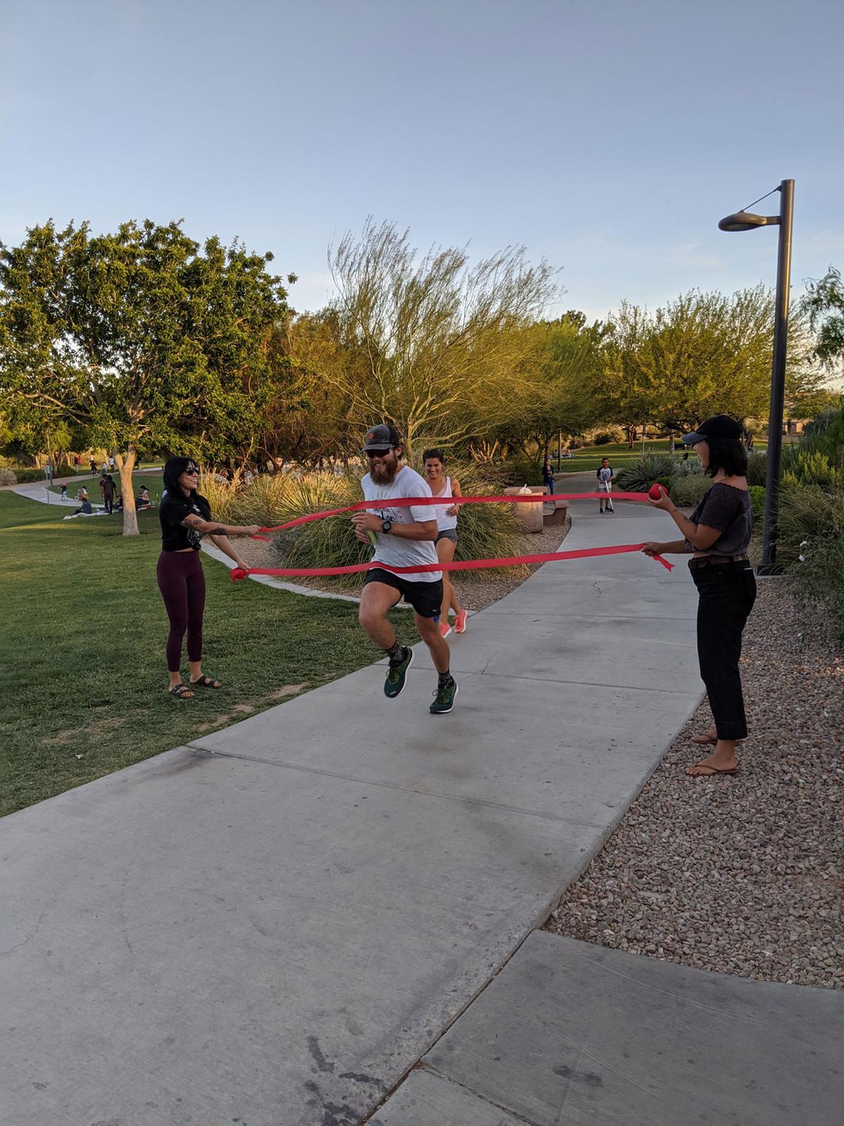 Makredes runs through red streamers to signify having completed 50 miles. (Courtesy of Peter Makredes)