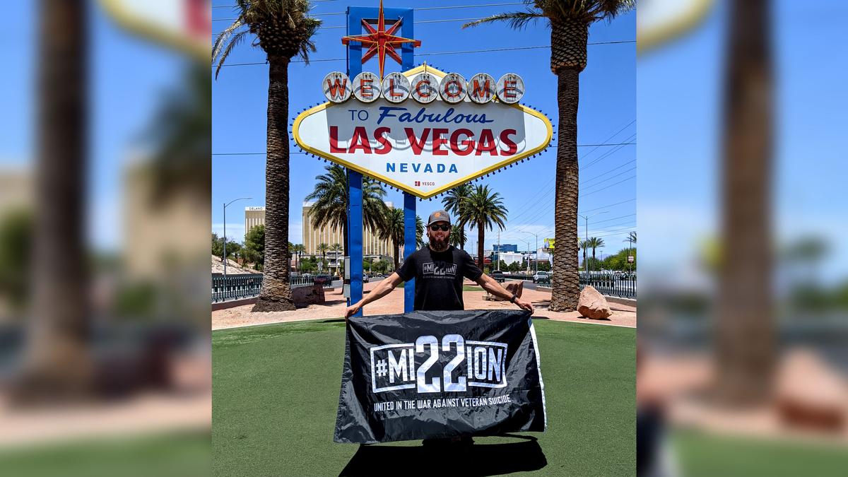 Peter Makredes holds a Mission 22 banner in Las Vegas. (Courtesy of Peter Makredes)