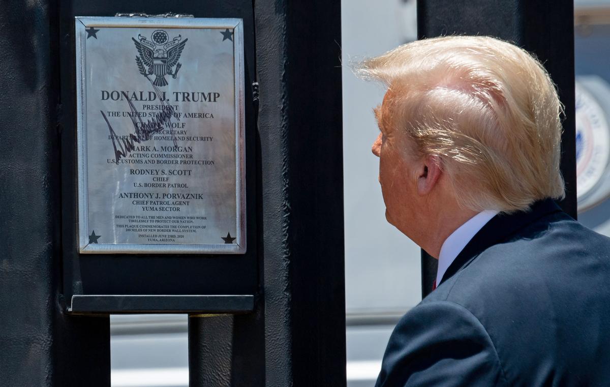 President Donald Trump looks at a plaque after signing it as he participates in a ceremony commemorating the 200th mile of border wall at the international border with Mexico in San Luis, Ariz., on June 23, 2020. (Saul Loeb/AFP via Getty Images)
