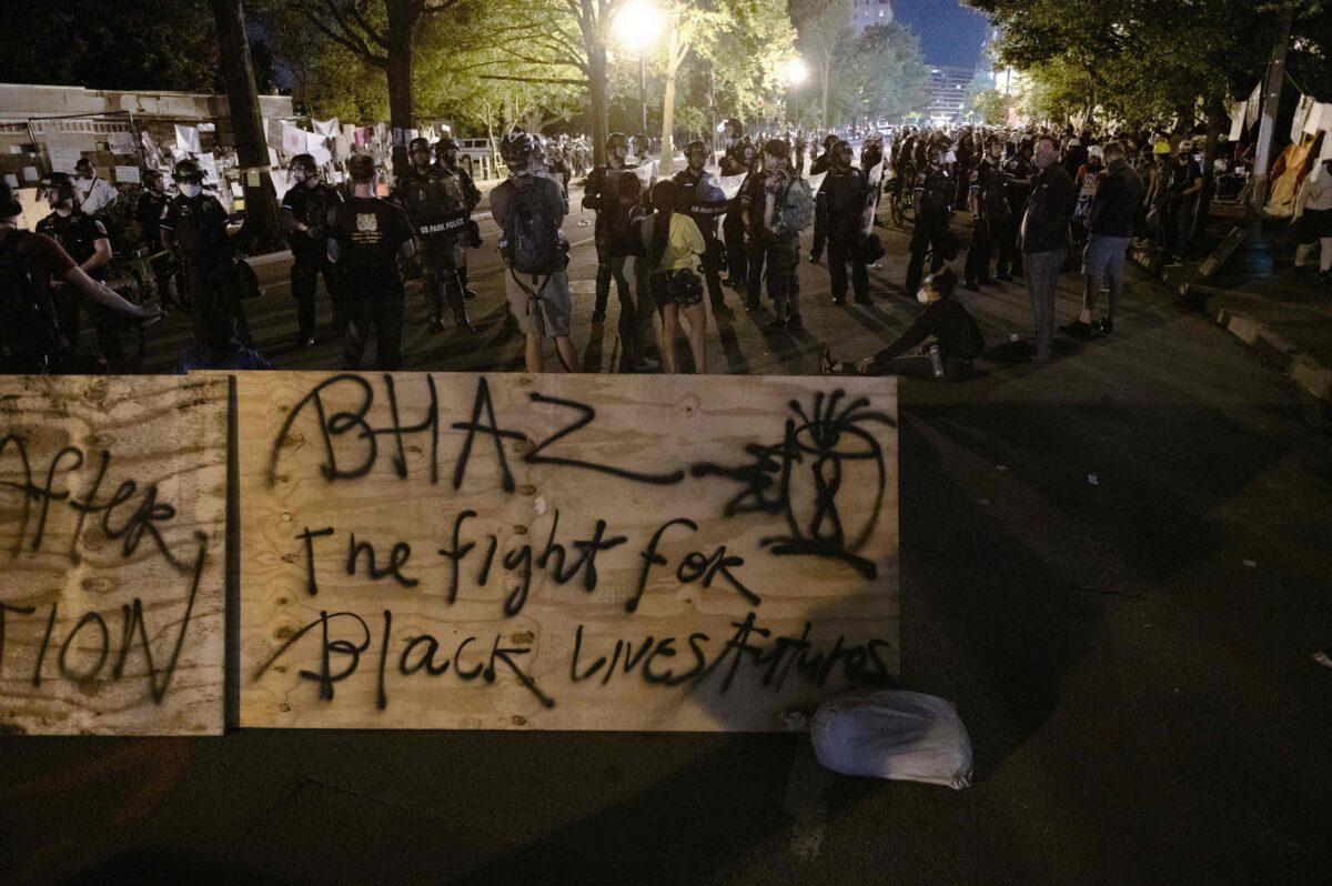 Protesters confront police near a barricade they erected and marked with the sign "Black House Autonomous Zone" in front of Lafayette Park near the White House in Washington on June 22, 2020. (Roberto Schmidt/AFP via Getty Images)