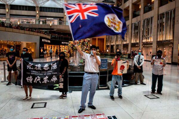 A pro-democracy protester waves a British colonial flag during a "Lunch With You" rally at a shopping mall in the Central district in Hong Kong on June 1, 2020. (Issac Lawrence/AFP/Getty Images)