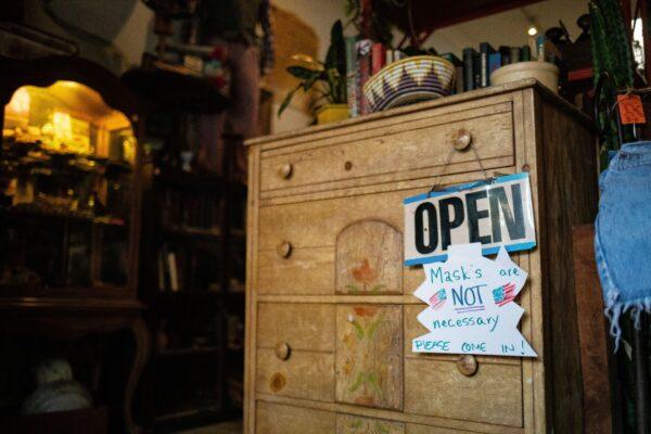 A sign in MMD Antiques lets customers know that masks are optional in the store, in Orange, Calif., on June 19, 2020. (John Fredricks/The Epoch Times)