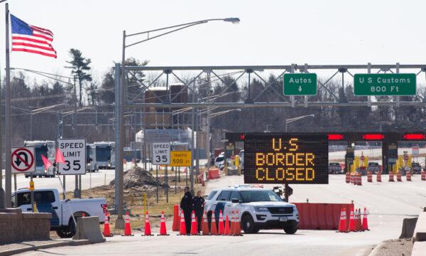 U.S. Customs officers stand beside a sign saying that the US border is closed at the US-Canada border in Lansdowne, Ontario, on March 22, 2020. (Lars Hagberg/AFP via Getty Images)